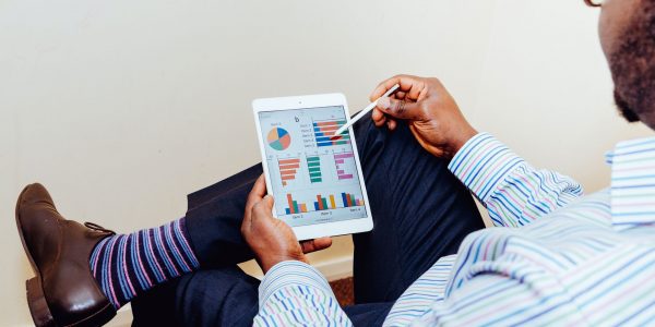 Mann betrachtet Sales Statistiken auf Ipad